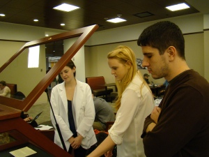 Conservation assistants Anna Whitham '15 (on left) and James Heffernan '15 help Emma Dwyer '16 install one of the class's exhibits in the O'Neill Reading Room. Photograph by Burns Conservator Barbara Adams Hebard.